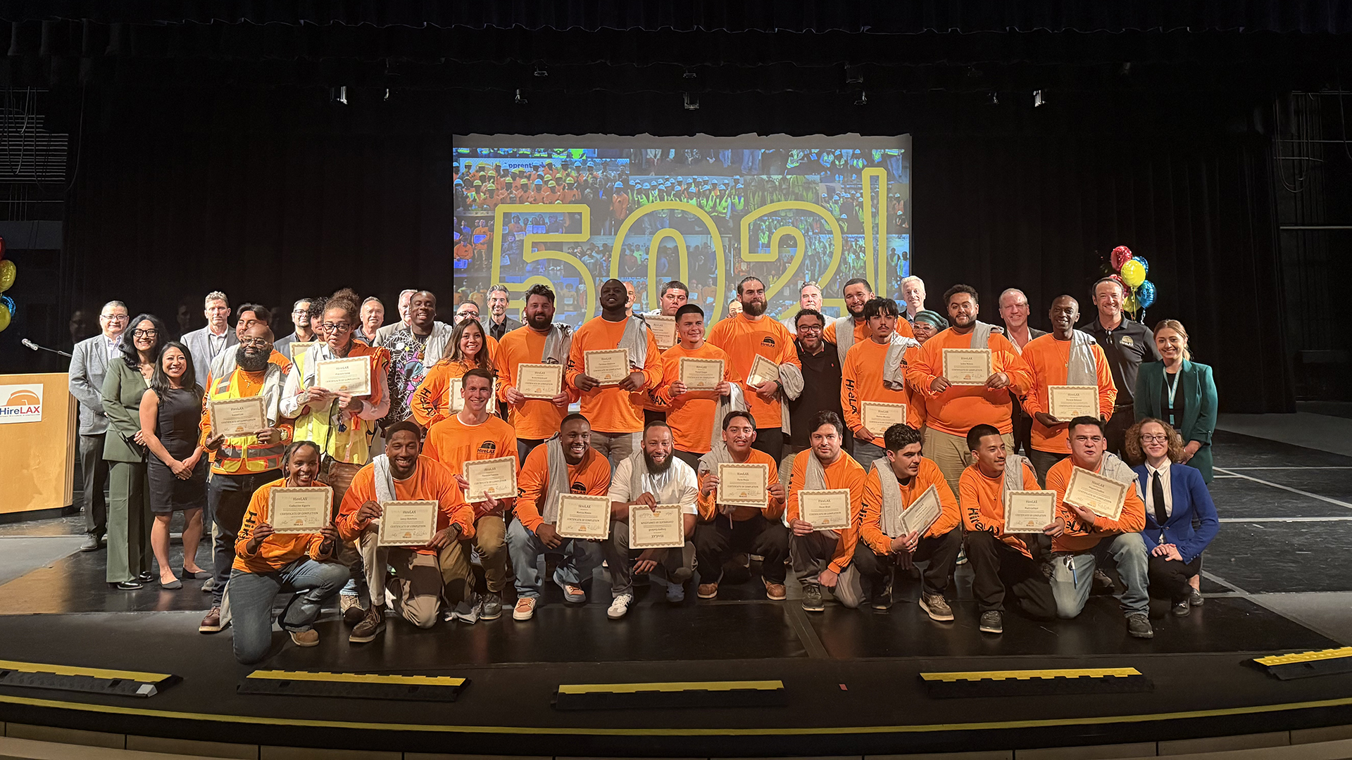 Graduates of the HireLAX Apprenticeship Readiness Program assembled with LAWA executives and program staff members at The Little Theater at Los Angeles Southwest College on Friday, Oct. 18, 2024. 